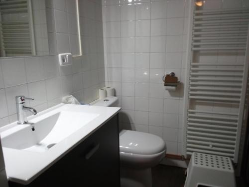 biała łazienka z umywalką i toaletą w obiekcie LA NURSERY DE MAS GUILLO w mieście San Quintín de Mediona