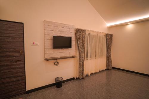a room with a flat screen tv and a window at KINGS RESORT DANDELI in Dandeli