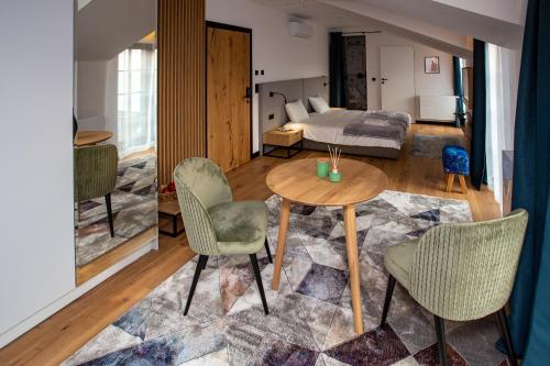 ein Wohnzimmer mit einem Tisch, Stühlen und einem Bett in der Unterkunft Ogrodowa Premium in Gorlice