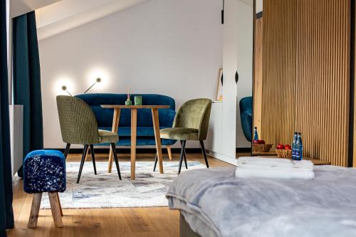 a bedroom with a table and chairs and a blue couch at Ogrodowa Premium in Gorlice