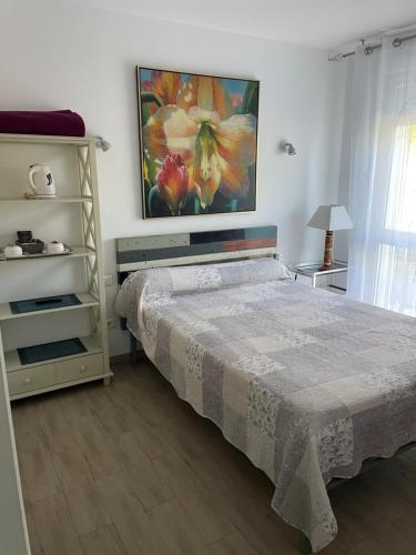 a bedroom with a bed and a painting on the wall at L'Abribis in Firminy