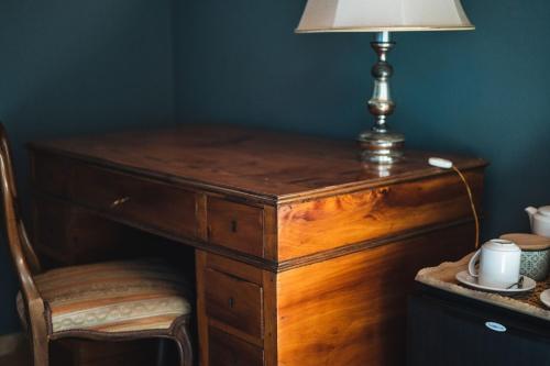 a wooden desk with a lamp and a chair at Casa di Melo - Organic Country Hotel in Cassibile