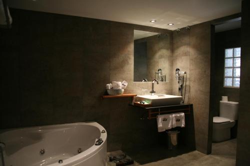 a bathroom with a tub and a sink and a mirror at Montaltmar in Sant Vicenç de Montalt