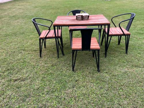 a wooden table with two chairs and a table with two glasses at ArushaWest in Arusha