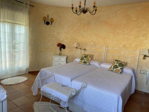 a bedroom with two beds and a chandelier at CASA SEBASTIANA SUITE in Losar de la Vera