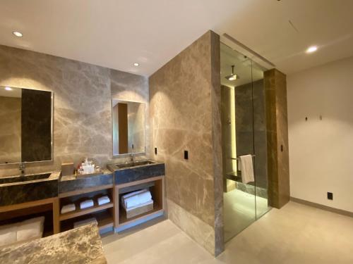 a bathroom with a shower and two sinks and a glass shower stall at Dreams Bahia Mita Surf and Spa - All Inclusive in Punta Mita