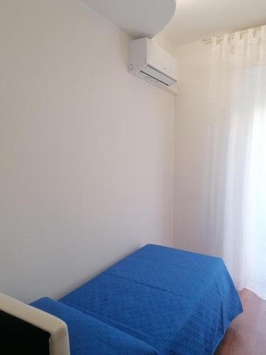 a bedroom with a blue bed and a window at IN CENTRO in Porto SantʼElpidio