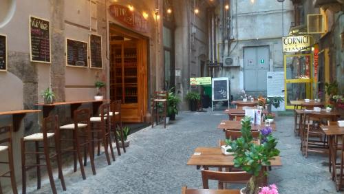 ナポリにあるベッド ＆ ブレックファースト カーサ マリエラの木製のテーブルと椅子が備わる空きレストランです。