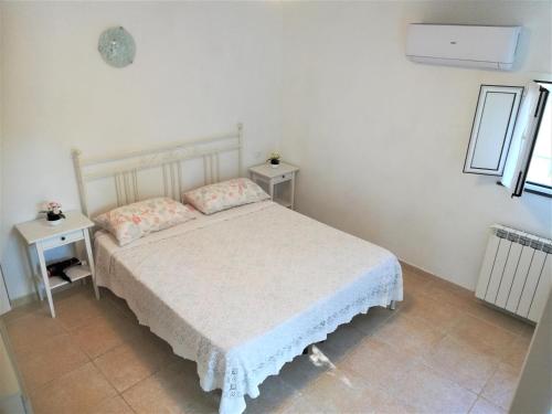 1 dormitorio con 1 cama blanca y 2 mesas en Lucrae', en Finale Ligure