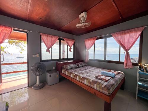 a bedroom with a bed with a view of the ocean at Char Bungalows in Koh Tao