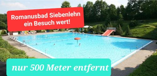 a large swimming pool with a sign in front of it at Kleines Gartenhaus am Mahler in Großschirma