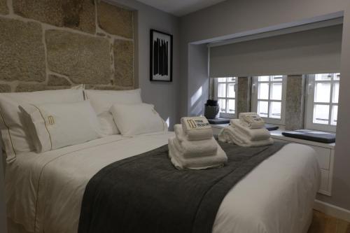 um quarto com uma cama grande e toalhas em Torre Medieval em Viseu