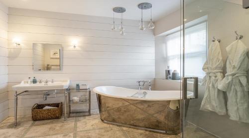 a bathroom with a tub and a sink at Merchants House in Salcombe