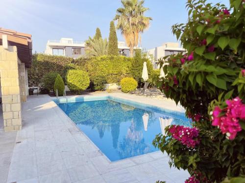 una piscina en un patio con flores en Villa14 Sea Breeze, en Klorakas