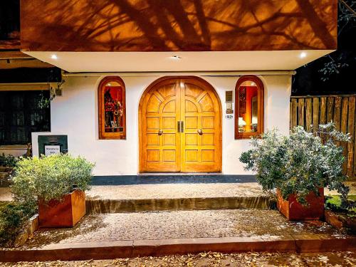 a house with a wooden door and some plants at Posada Del Fin Del Mundo in Ushuaia