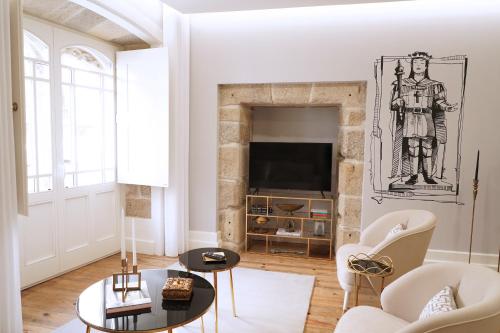 a living room with a fireplace and a tv at Torre Medieval in Viseu