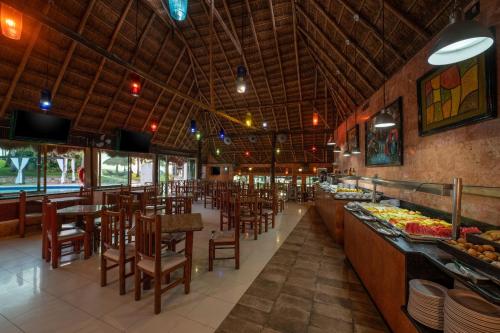 Hotel Dos Playas Faranda Cancún في كانكون: غرفة طعام مع طاولات وكراسي في مطعم