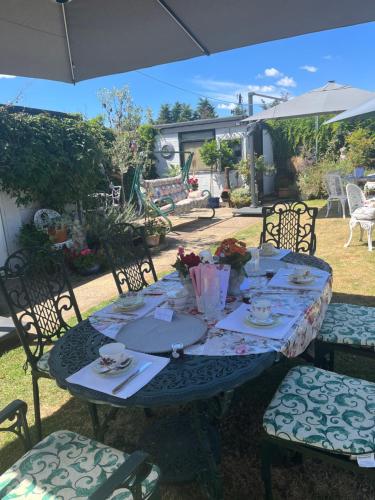 a table with chairs and an umbrella in a yard at Southend Airport Bed & Breakfast in Rochford