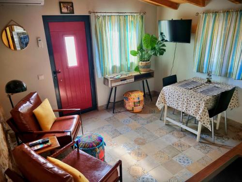 a living room with a red door and a table at Quinta do Cabril in Serpins