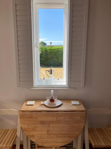 a table in front of a window with a plate on it at Hunters Moon B&B in North Tidworth