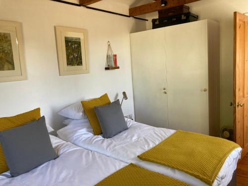 a bedroom with a bed with white sheets and yellow pillows at Hunters Moon B&B in North Tidworth