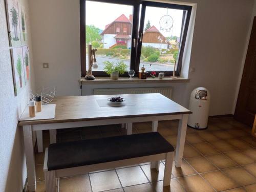 Hitzerode的住宿－Idyllisches Ferienhaus “Werra Ausblick” am Meißner，窗户房间里一张桌子和长凳