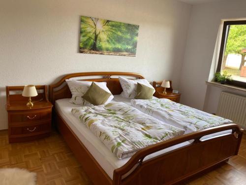 sypialnia z dużym łóżkiem z drewnianą ramą w obiekcie Idyllisches Ferienhaus “Werra Ausblick” am Meißner w mieście Hitzerode