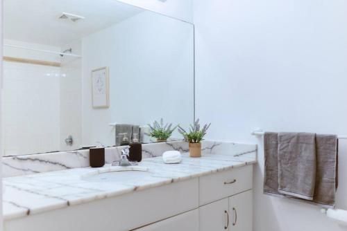 a white bathroom with a sink and a mirror at Amazing Studio Apt @BRICKELL With pool & Parking in Miami