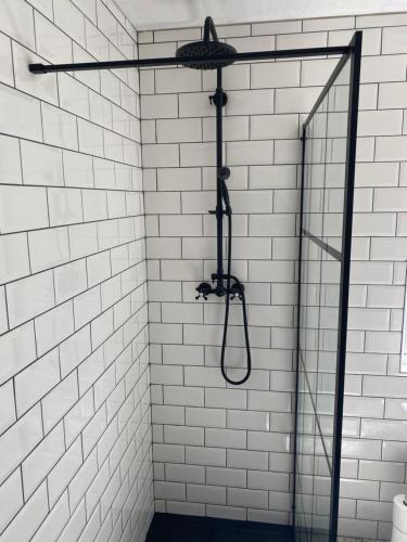 a shower in a bathroom with white tiles at River View Lodge in Felton