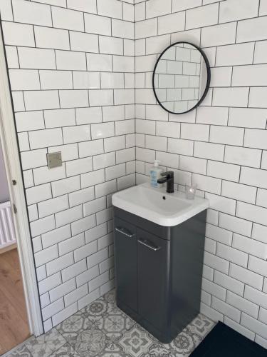 a white tiled bathroom with a sink and a mirror at River View Lodge in Felton