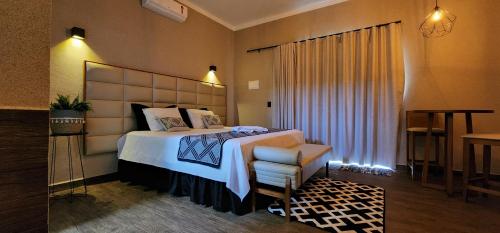 a hotel room with a bed and a chair at Pousada Lago Azul in Delfinópolis