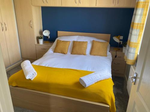 River View Lodge في Felton: سرير ذو أغطية ومخدات صفراء وبيضاء