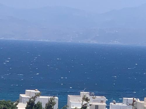 a view of the ocean with white buildings and houses at sun senses luxury Vilas Dione in Piso Livadi