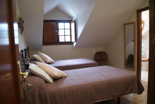 a bedroom with two beds and a window at El ParaÍso de Guriezo in Pomar