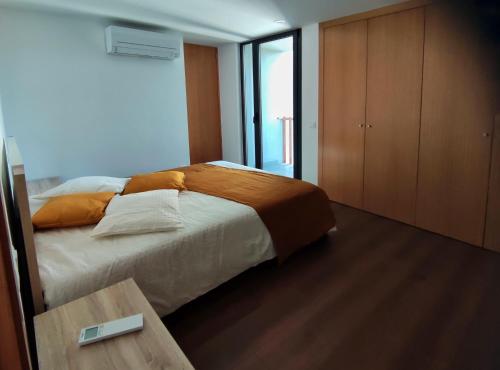 a bedroom with a large bed and a wooden table at Casa João Eusébio 1 in Ponte de Lima