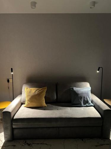 a couch with two pillows on it in a living room at The SPOT apartments - Orbi Beach Tower in Batumi