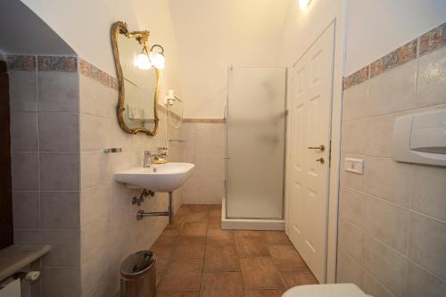 a bathroom with a sink and a toilet and a mirror at Masseria Del Crocifisso in Polignano a Mare