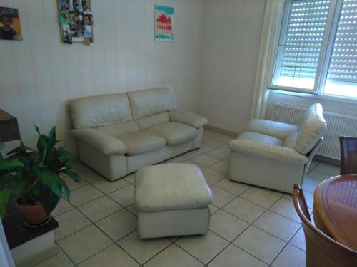 a living room with a couch and a chair at Chambres dans maison proches Nantes et Vallet in Le Landreau