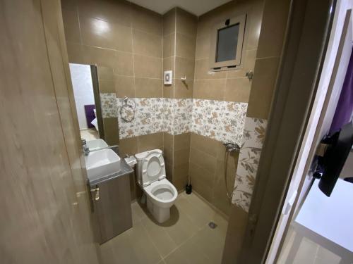 a small bathroom with a toilet and a sink at Hôtel Chark in Guercif