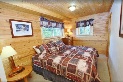 - une chambre avec un lit dans une cabane en rondins dans l'établissement Red Cedar, à West Yellowstone