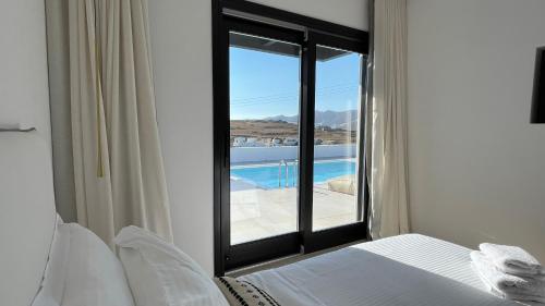 a bedroom with a window with a view of a pool at Best1 Villa in Klouvas