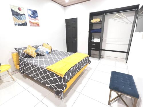 a bedroom with a bed and a yellow blanket at Tuareg Place Aeropuerto AC in Alajuela