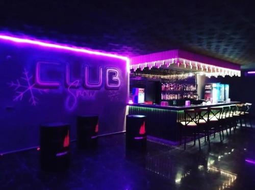 a nightclub with a bar with purple lights at Snowflake Dag Hotel & SPA in Sarıkamıs