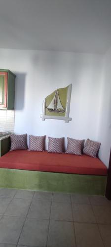 a red couch sitting against a white wall at Ammos 1 in Panteli