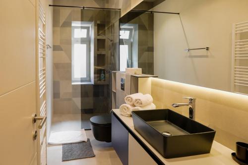 a bathroom with a black sink and a toilet at Lofty Exclusive Apartments in Sarajevo