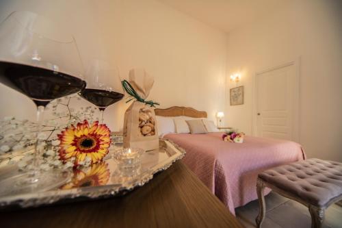 a bedroom with a bed and a table with wine glasses at Masseria Del Crocifisso in Polignano a Mare