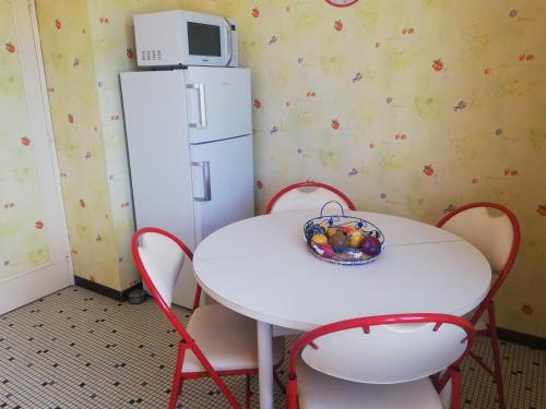 a white table with chairs and a white refrigerator at L'Opaline, Jolie Maison avec Jardin 6 pers,10km Honfleur, linge et internet inclus in Beuzeville