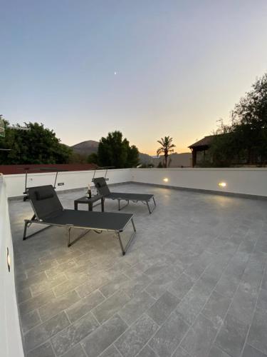 a patio with two chairs and a table on a roof at FronteMare in Palermo
