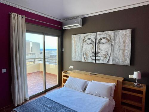 a bedroom with a painting of a face on the wall at Villa Ocean Beach in El Médano