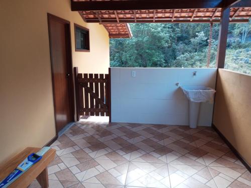 a room with a bathroom with a toilet and a window at Pousada Recanto da Serra in São Pedro da Serra